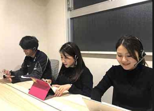 女性社員2名と男性社員1名が並んで座っていて、パソコンに向かいコールセンター業務を行っている画像